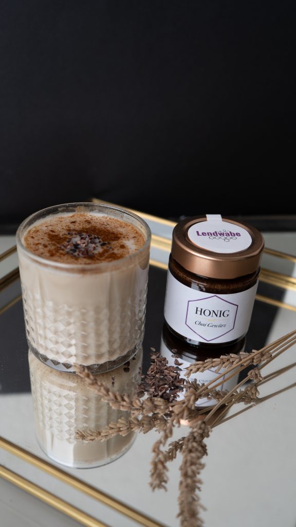 Honig-Chai-Latte im Glas neben dem Honigglas